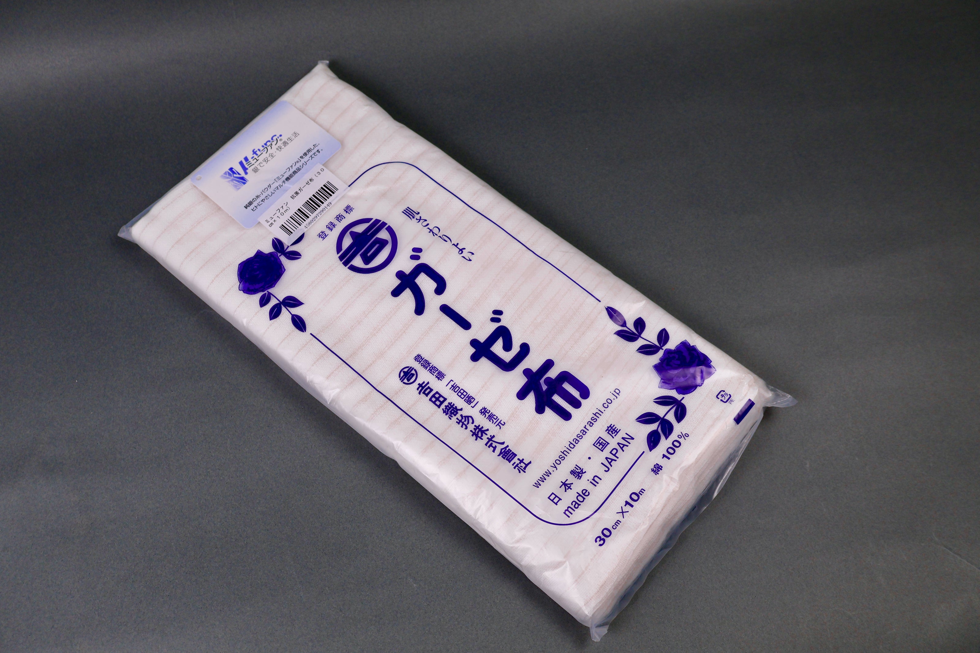 clear packaged antibacterial gauze cloth package shows blue print of hiragana and floral pattern on dark grey background