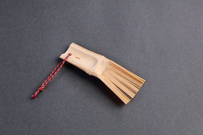 small bamboo brush for wasabi ginger sesame seed handmade in Japan angled shot with dark grey background