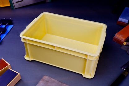 tall yellow knife sharpening box rectangular shaped surrounded by knife sharpening accessories on dark blue grey surface