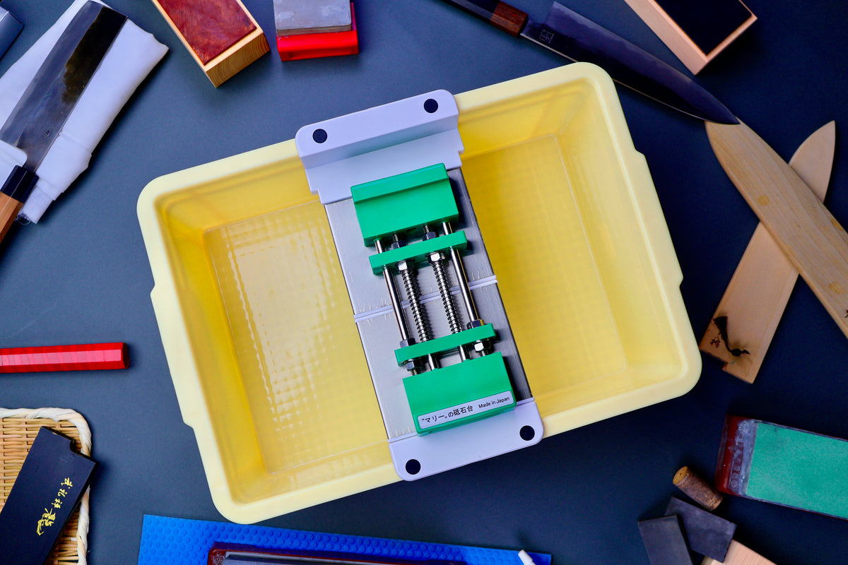 sharpening kit with yellow tall container holding suehiro bridge Marie Whetstone Holder and hasegawa non slip mat in background with accessories 