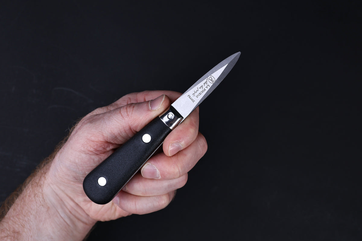 Laguiole Neron oyster knife — La Fourmi blade stamp, bolster, and handle detail on wood surface
