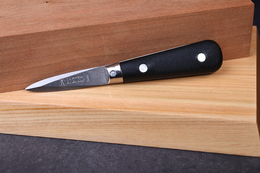 Laguiole Neron oyster knife — La Fourmi blade stamp, bolster, and handle detail on wood surface