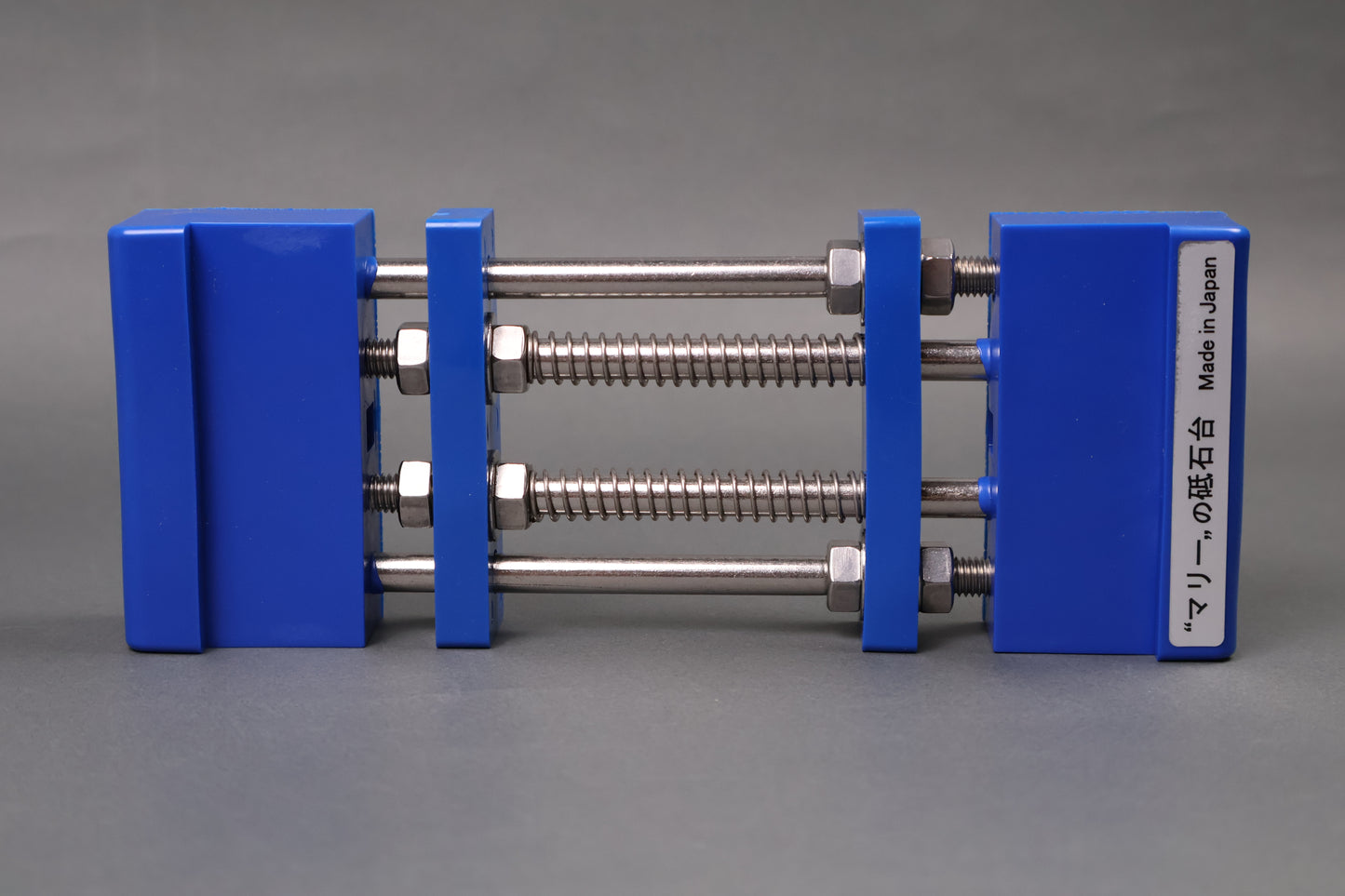 marie whetstone holder red rectangular shaped on its side showing blue pvc body stainless steel rods springs grey backdrop