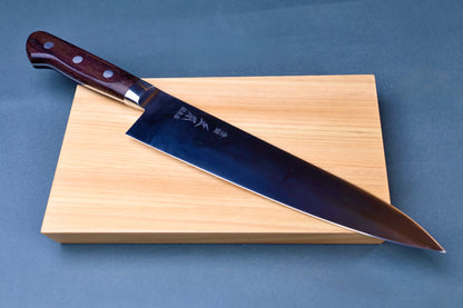Masamoto CT carbon steel gyuto 240mm resting on hinoki cypress cutting board