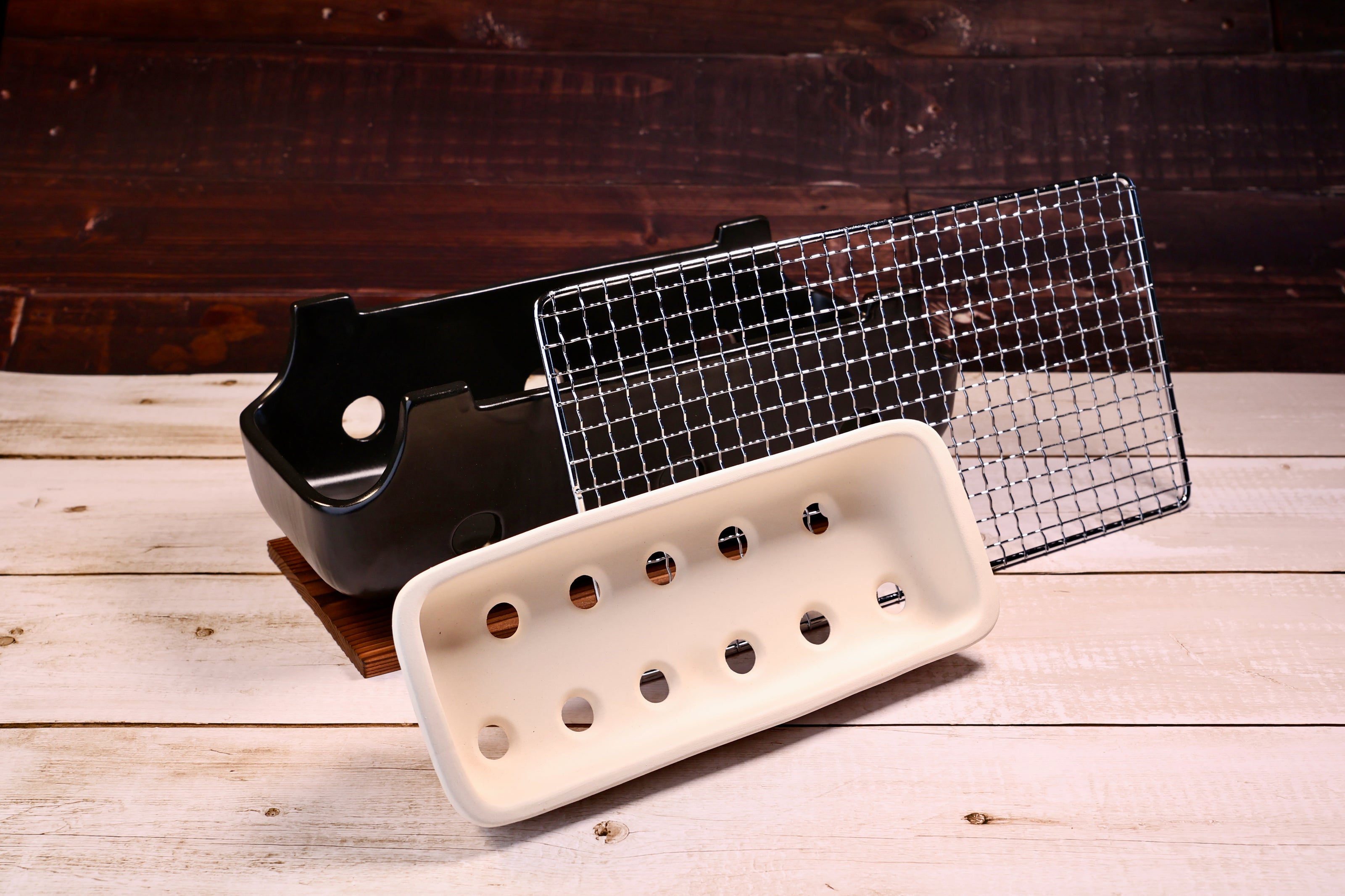 Misuzu Pottery Banko Yaki Konro Grill, disassembled showing black ceramic body, white clay ash catcher, and wire grate