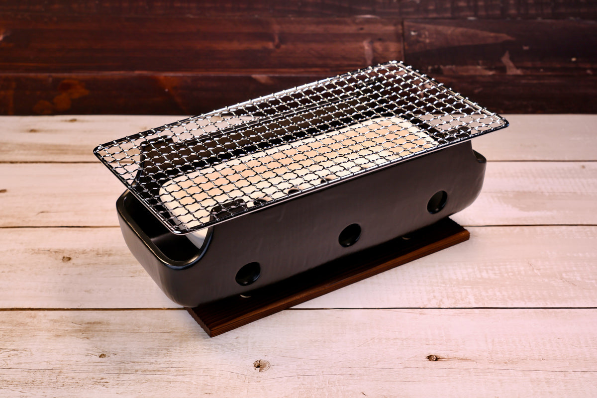 Misuzu Pottery Banko Yaki Konro Grill, three-quarter angled view showing black ceramic body, wire grate, and wood base