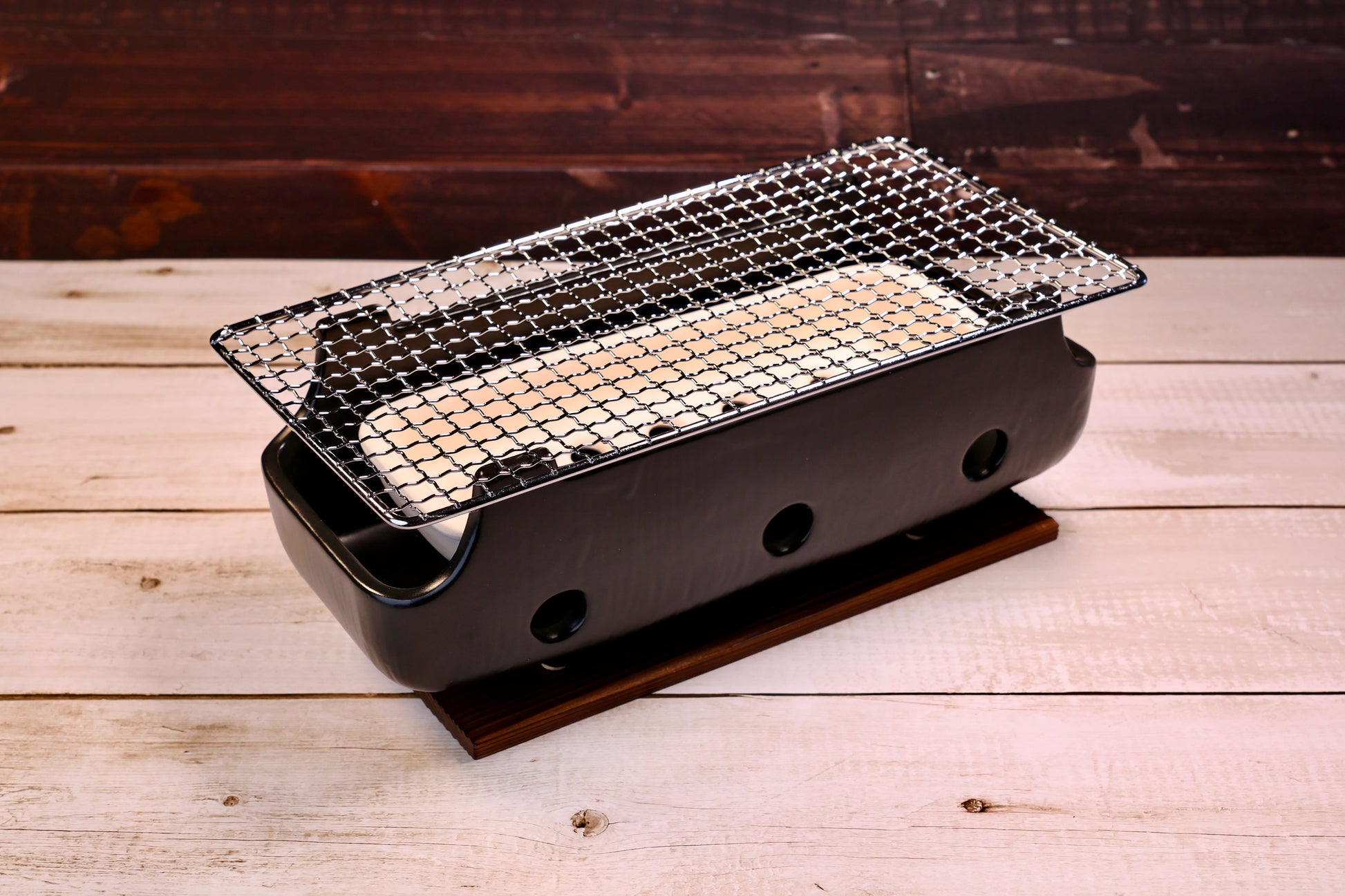 Misuzu Pottery Banko Yaki Konro Grill, three-quarter angled view showing black ceramic body, wire grate, and wood base