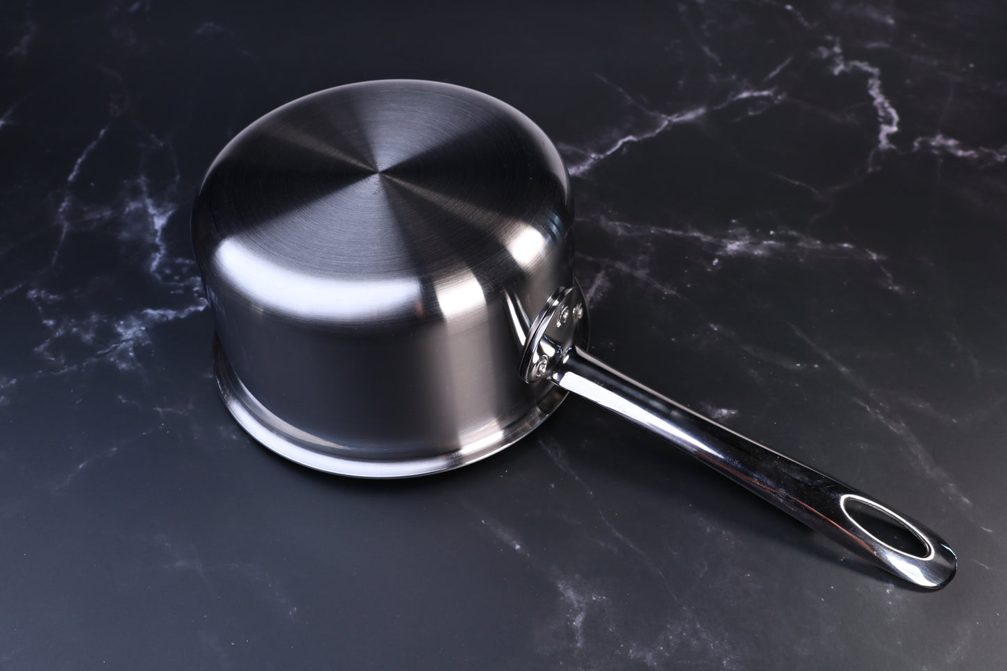 Mt. Fuji Steel Clad saucepan 16cm exterior showing brushed stainless clad bottom and long handle on marble