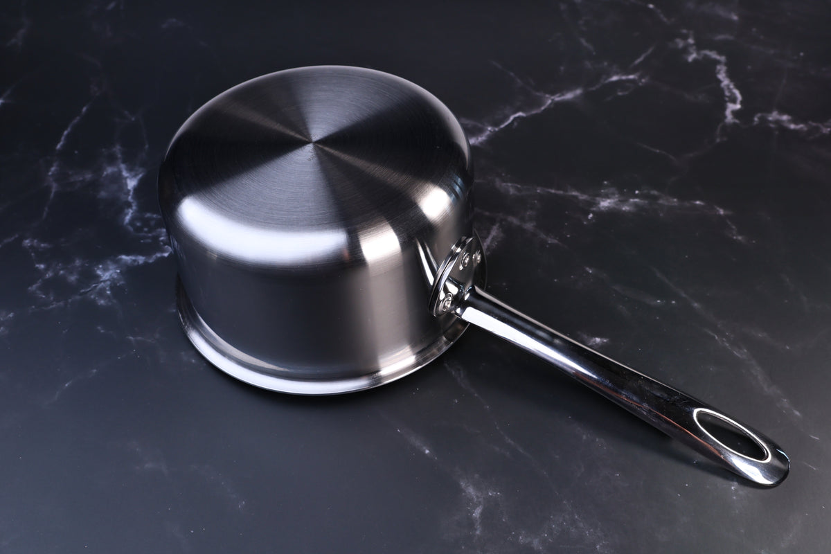 Mt. Fuji Steel Clad saucepan 16cm exterior showing brushed stainless clad bottom and long handle on marble