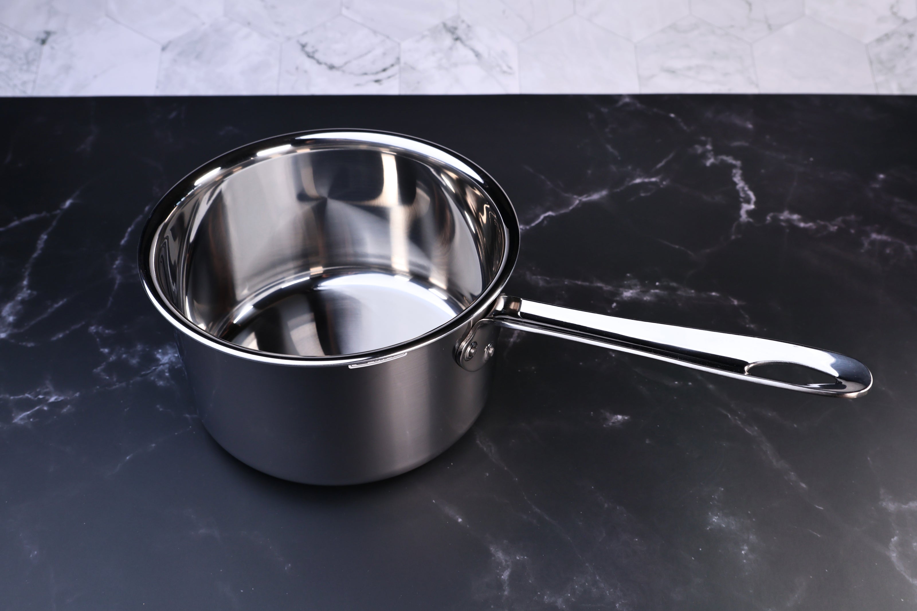 Mt. Fuji Steel Clad saucepan 18cm without lid showing polished stainless interior and loop handle on marble