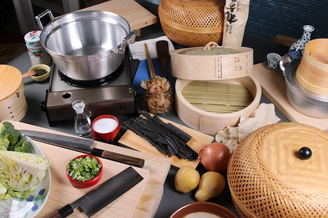 kitchenware scene showing chinese seiro aluminum pot wicker basket wood cutting board kitchen knives 