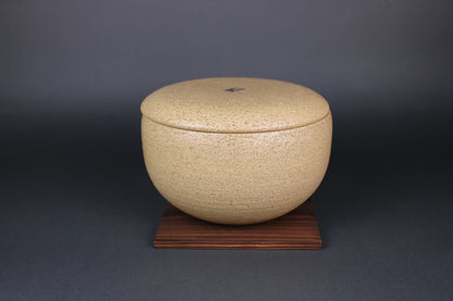 image showing ceramic bowl with lid sitting on dark brown wood panel for cooking rice and vegetables with dark grey background