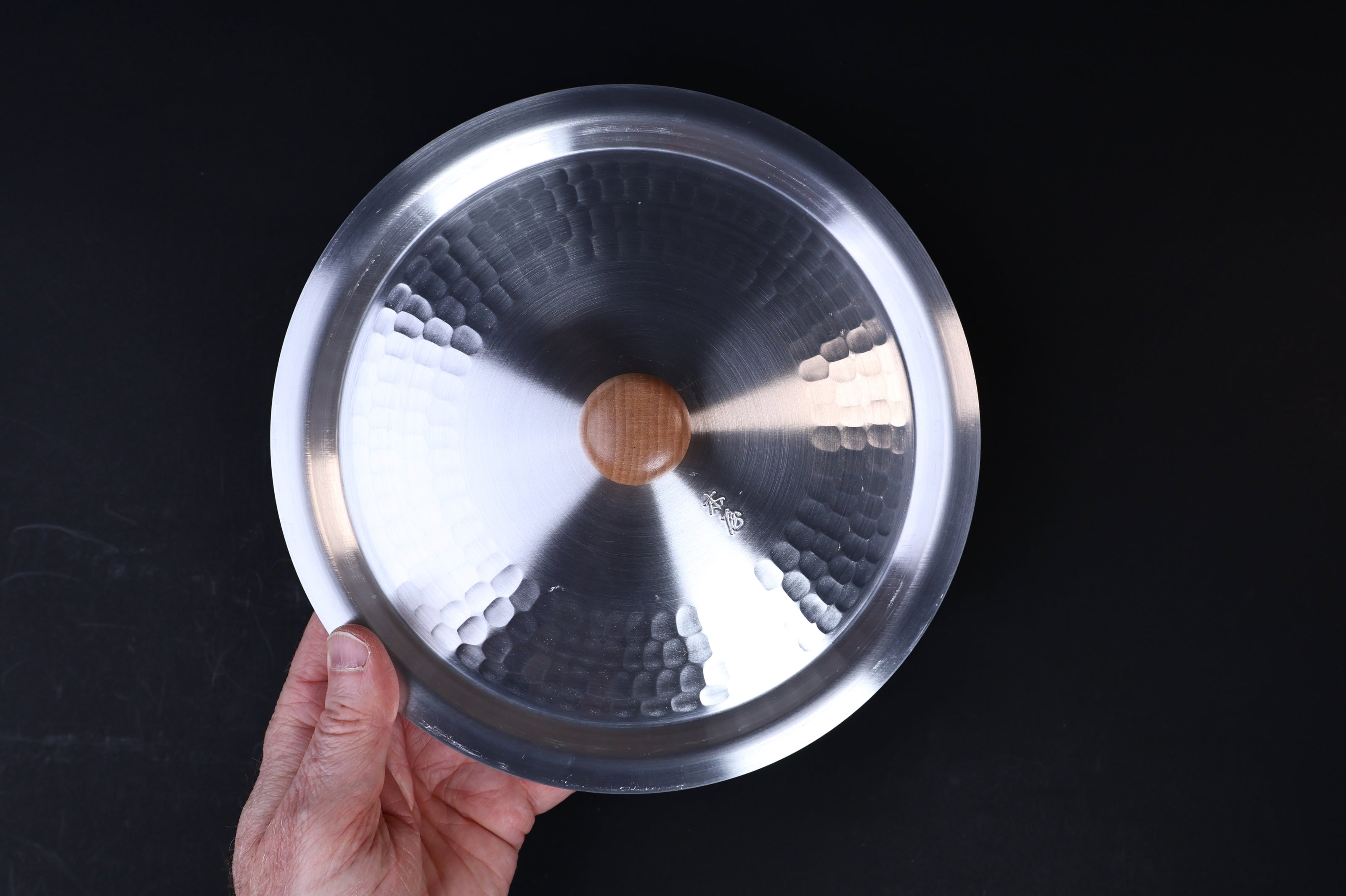 Nakamura Douki Dantsuki Seiro Pot Lid 21cm — held showing hammered aluminum interior and wood knob