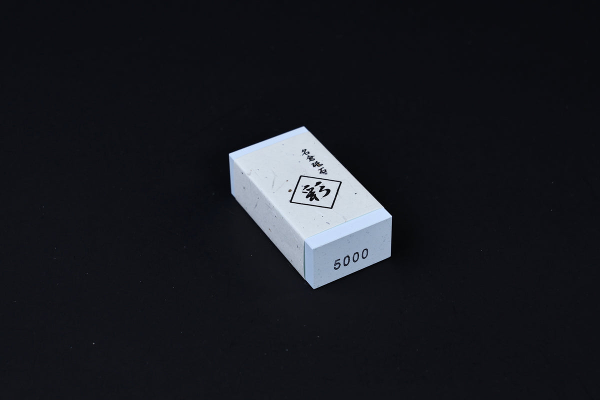 Naniwa Nagura stone 5000 grit angled on black background, grit number stamped on end clearly visible