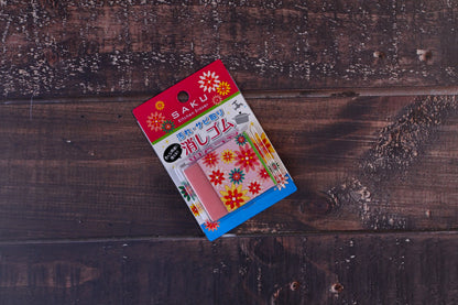 Naniwa Saku kitchen rust eraser — front of retail packaging showing pink abrasive eraser and floral card