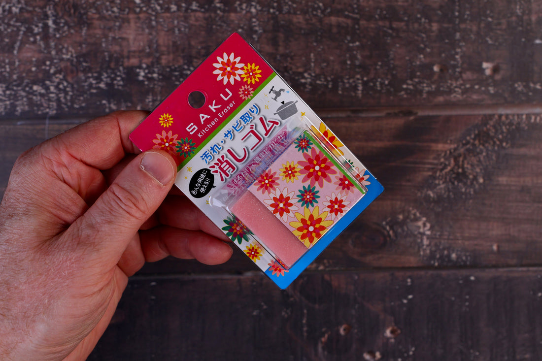 Naniwa Saku kitchen rust eraser — held in hand showing full packaging front and compact size