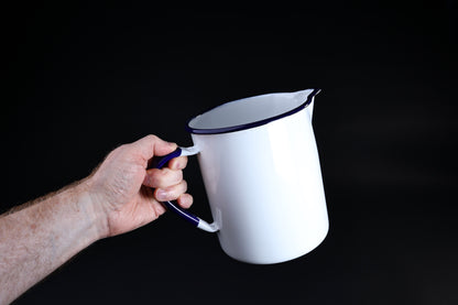 Noda Horo enamel measuring pitcher 2L — held by cobalt blue handle showing full side profile and size