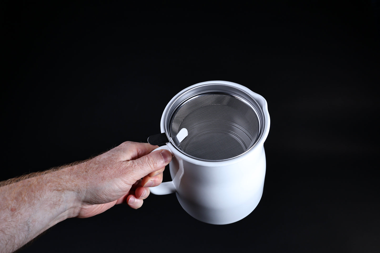 Noda Horo enamel oil pot — held open from above showing stainless mesh filter and filter handle detail