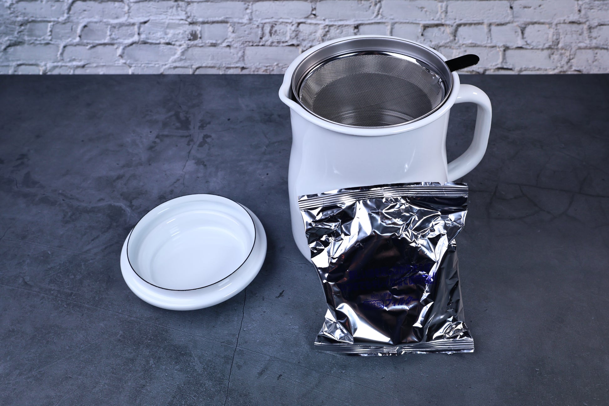 Noda Horo enamel oil pot — open showing filter and included charcoal refill packet alongside pot