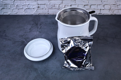 Noda Horo enamel oil pot — open showing filter and included charcoal refill packet alongside pot