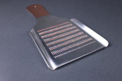  low profile shot backside of oroshigane grater fine spikes on silver colored body with grey bacground
