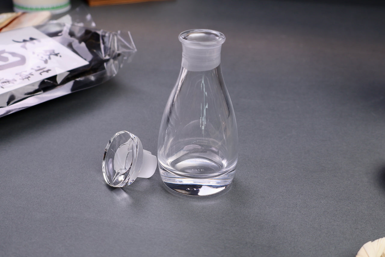 dripless pouring spoutless glass cruet for oil vinegar soy sauce front shot surrounding japanese kitchenware gray backdrop
