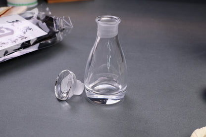 dripless pouring spoutless glass cruet for oil vinegar soy sauce front shot surrounding japanese kitchenware gray backdrop