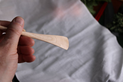 holding okubo house jam spoon showing underside with planing technique angles shown