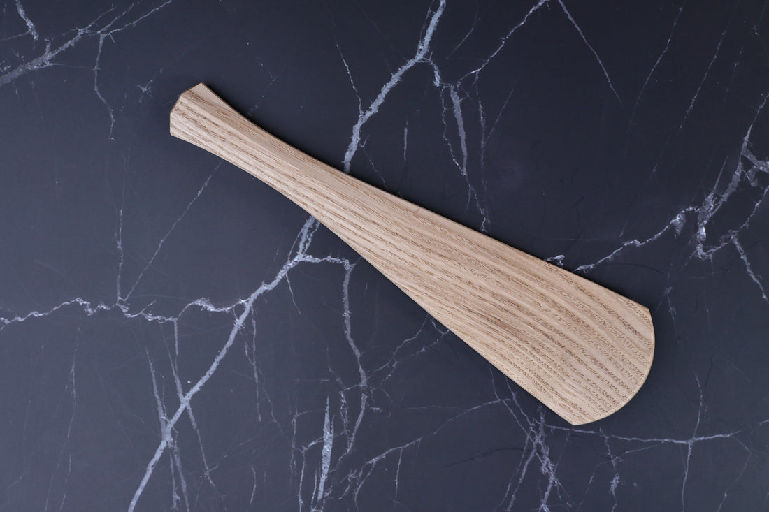 Okubo House chestnut rice paddle — face side top view showing wood grain on dark marble surface
