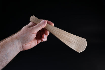 Okubo House chestnut rice paddle — held in hand, paddle face forward showing full form and grain detail