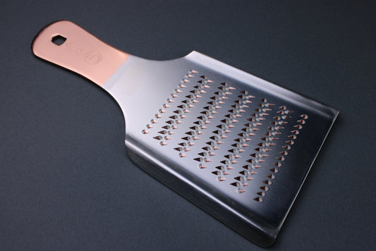 top view oroshigane copper grater dual sided no 5 by kanematsu copper colored handle and silver body showing sharp spikes with grey background