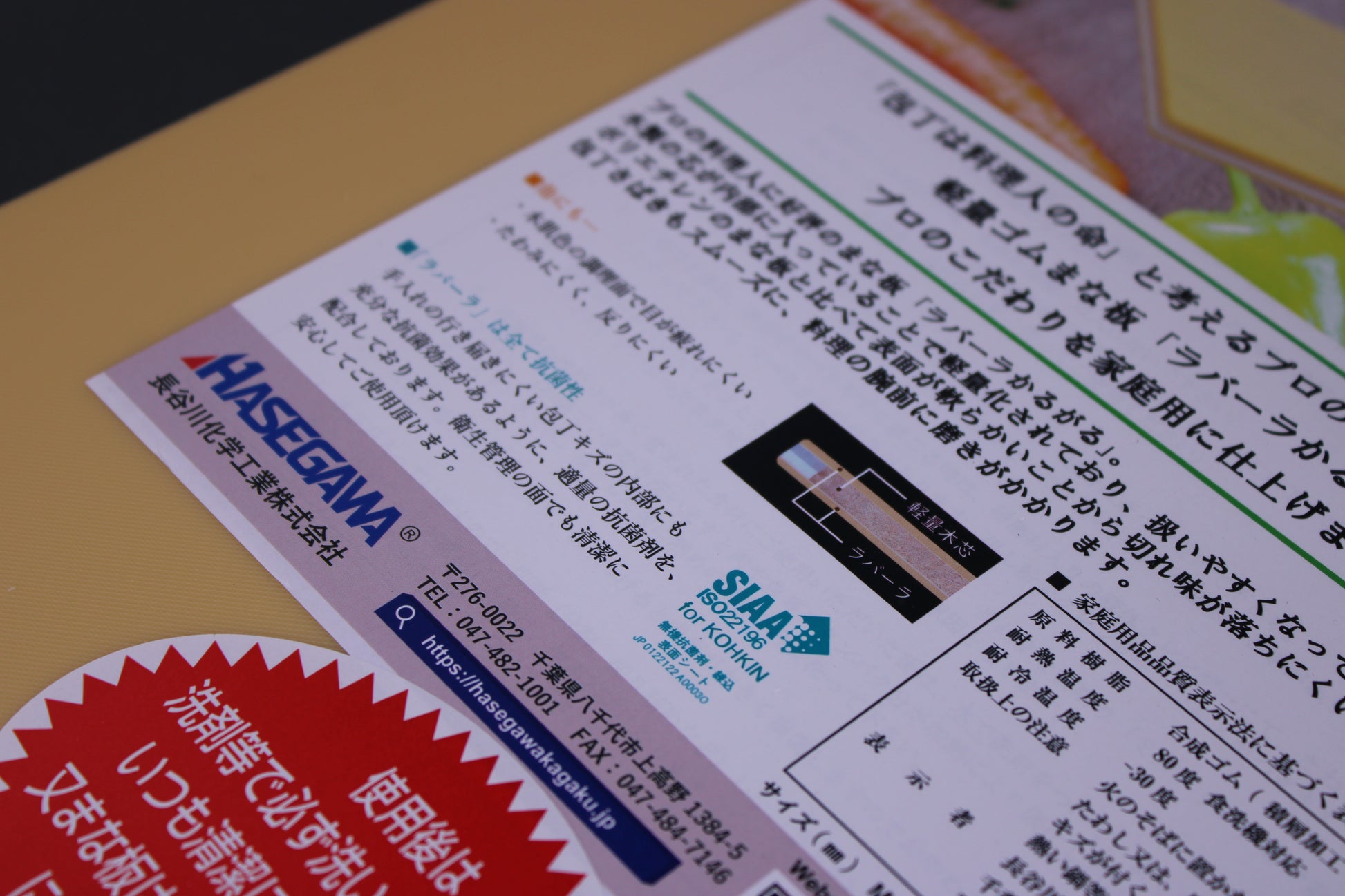 detailed closeup shot of japanese writing describing hasegawa rubber cutting board and the wood core surface white paper with image of inside the cutting board and a red banner with kanji writing 