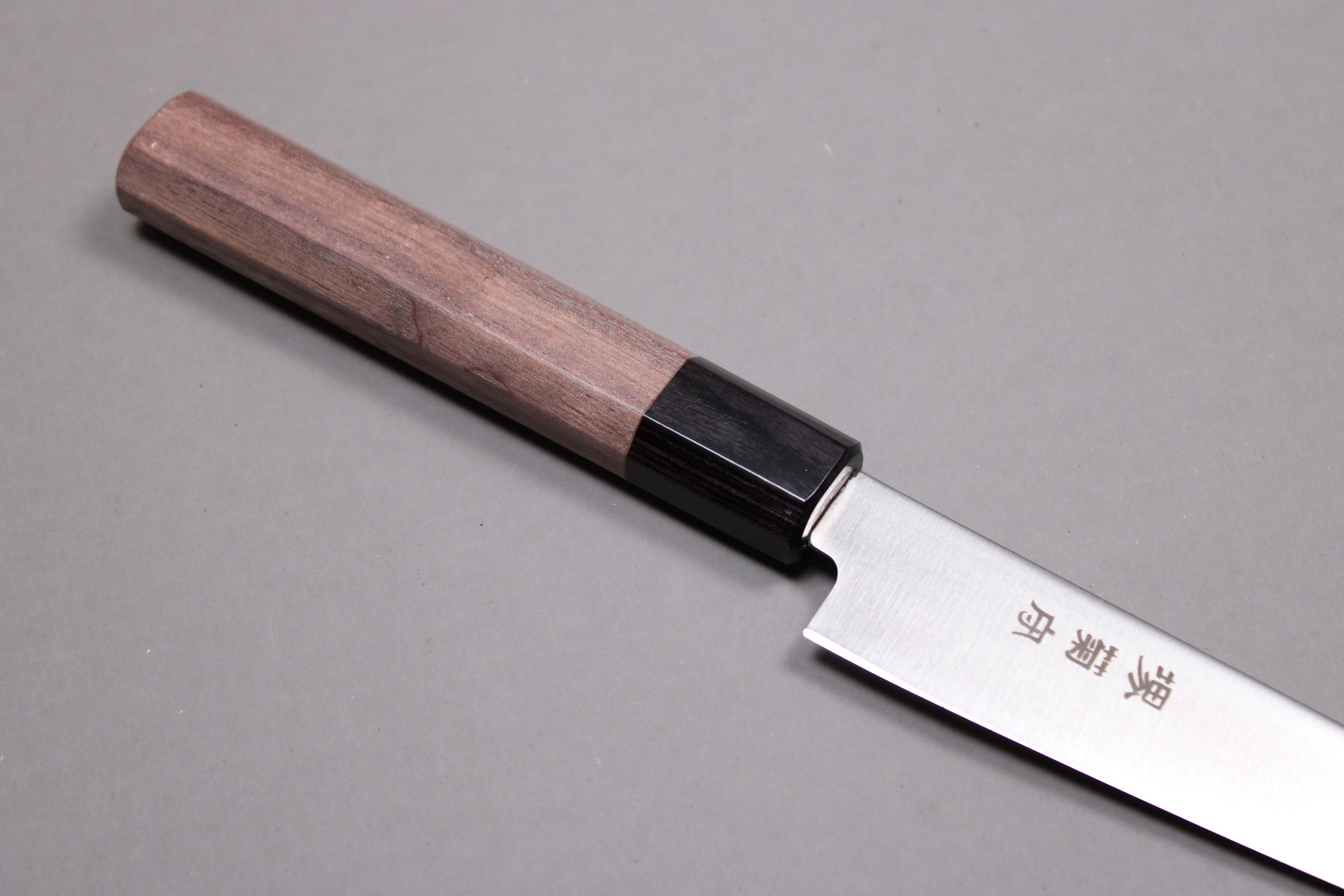 closeup shot knife choil buffalo horn ferrule and rosewood handle