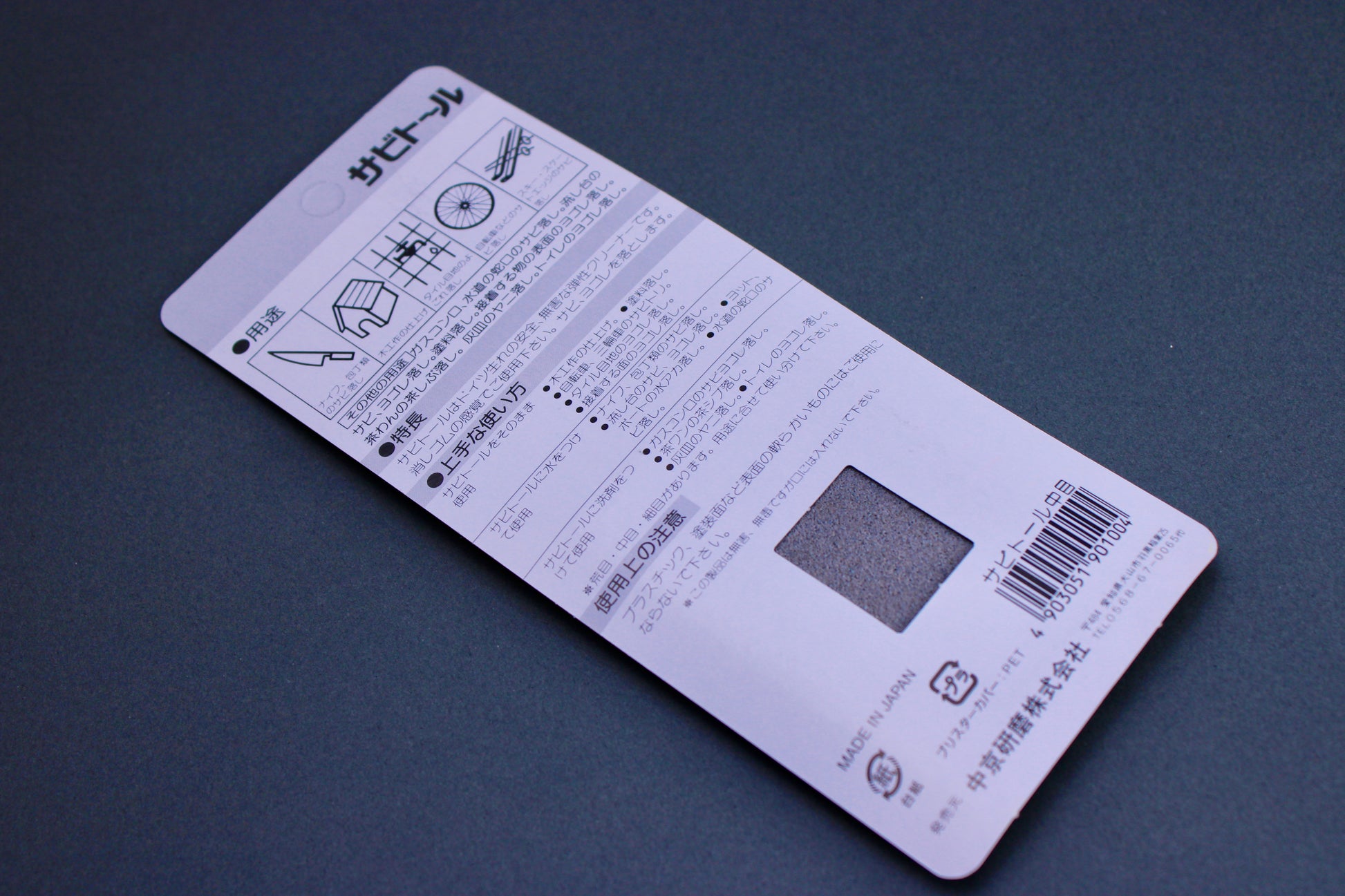 rectangular product packaging of rust eraser showing hiragana writing knife house wheel animation on grey background