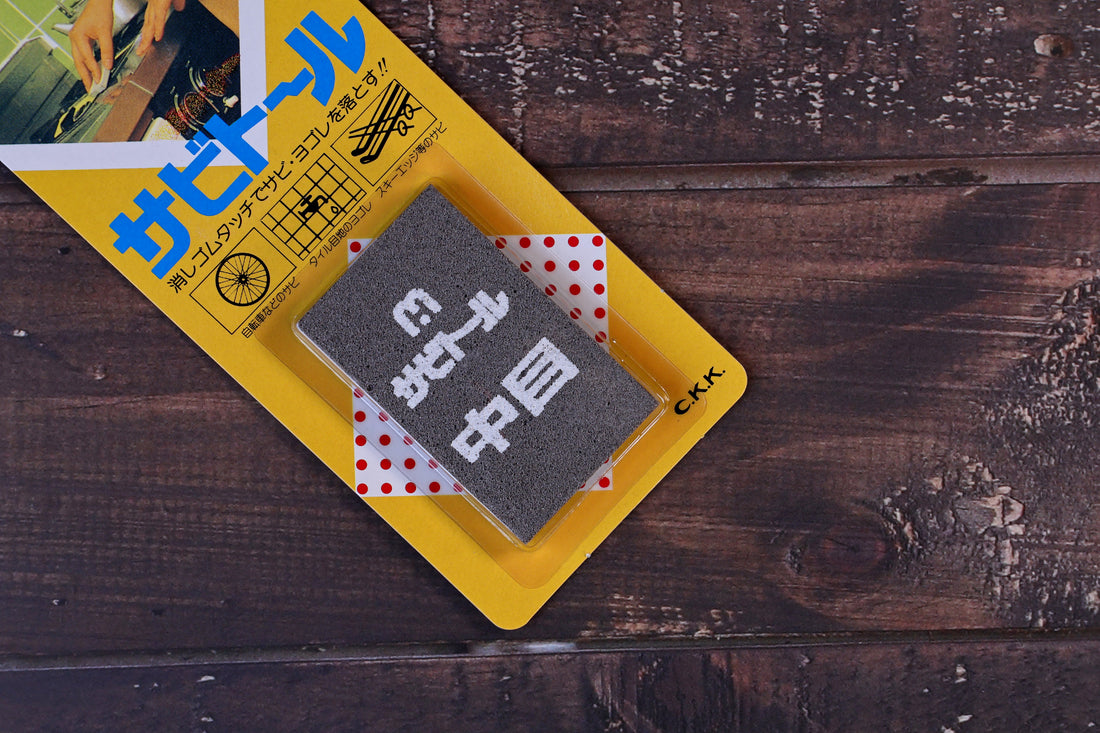 Sabitoru rust eraser medium — close-up of grey abrasive block face with Japanese text detail
