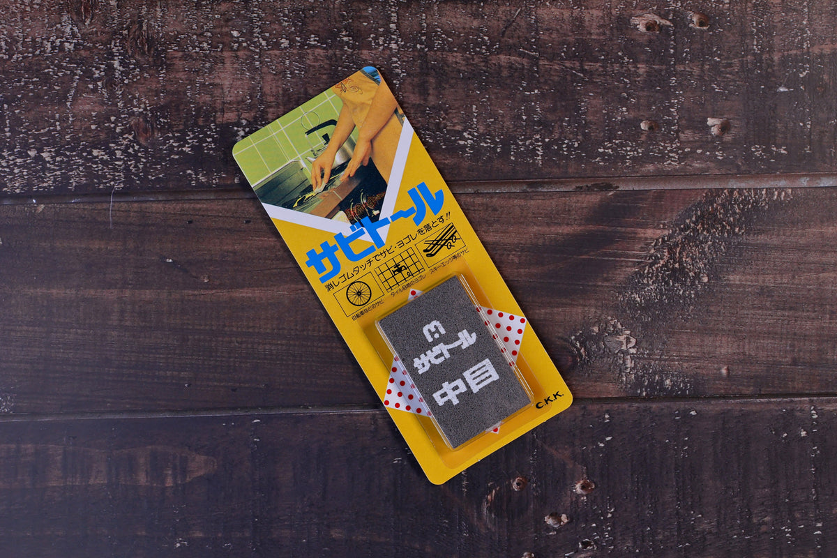 Sabitoru rust eraser medium — full product in yellow Japanese packaging, top view
