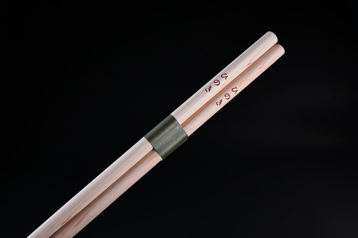 Saibashi round cooking chopsticks — close-up of handle end showing kanji stamp and green paper band detail