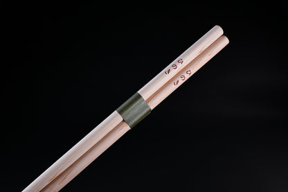 Saibashi round cooking chopsticks — close-up of handle end showing kanji stamp and green paper band detail