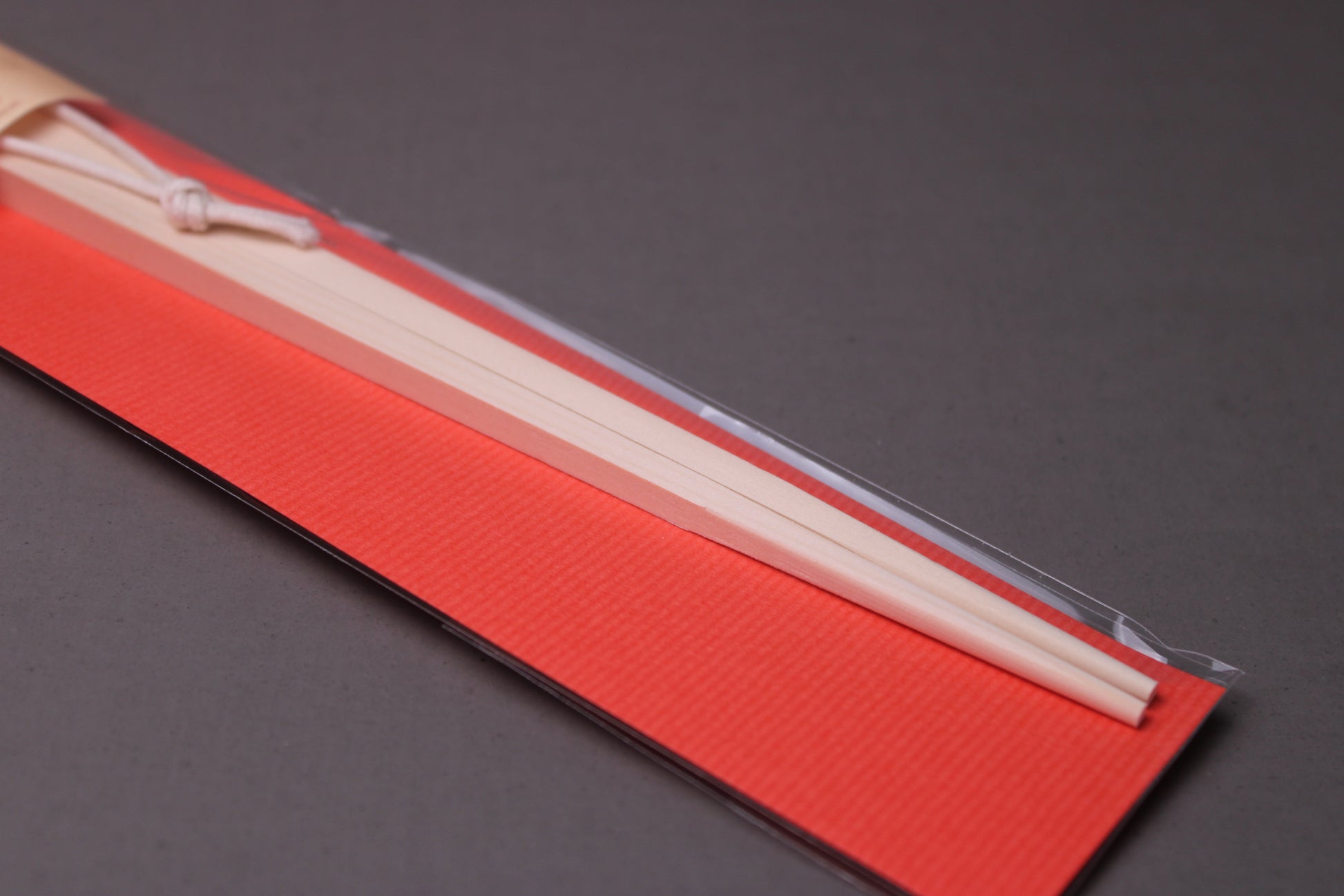 saibashi square cooking chopsticks by yamacoh youbi kisou life packed in clear plastic with red paper backing and sticker writing hinoki in hiragana with grey background closeup of bottom of package
