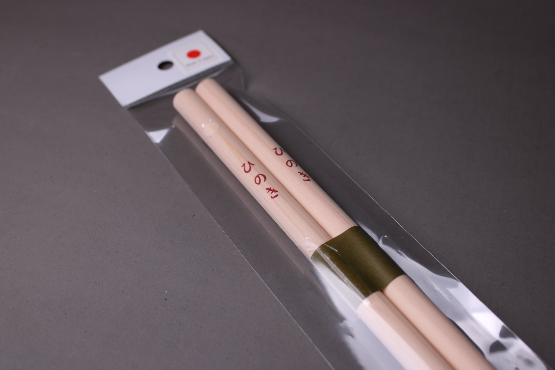  saibashi round cooking chopsticks by yamacoh youbi kisou life packed in clear plastic with red paper backing and sticker writing hinoki in hiragana with grey background closeup of chopsticks