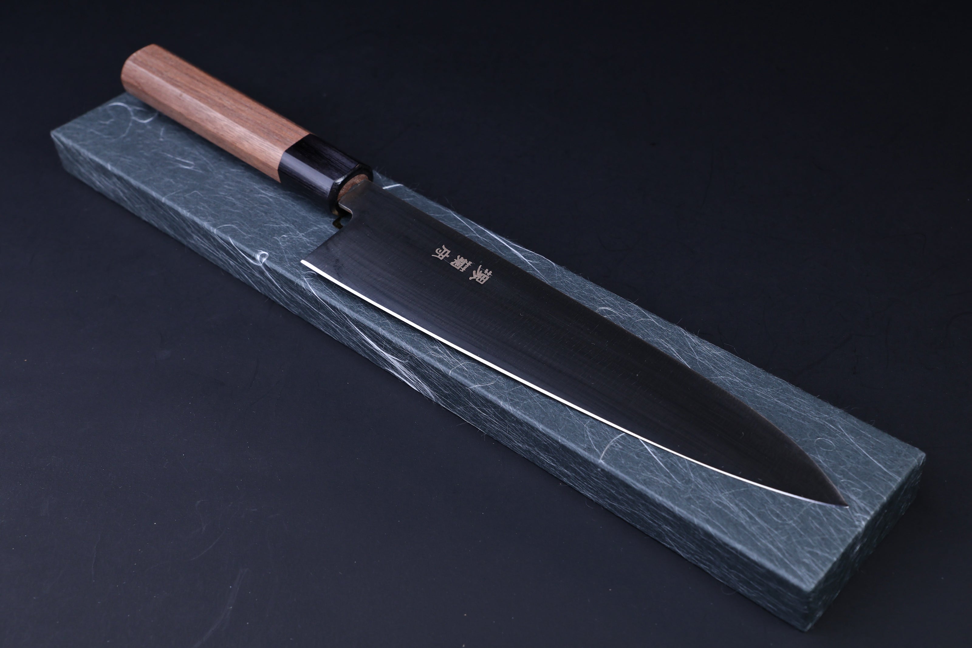 Sakai Kikumori Wasiki gyuto 210mm — resting on traditional Japanese knife box, blade and handle side view