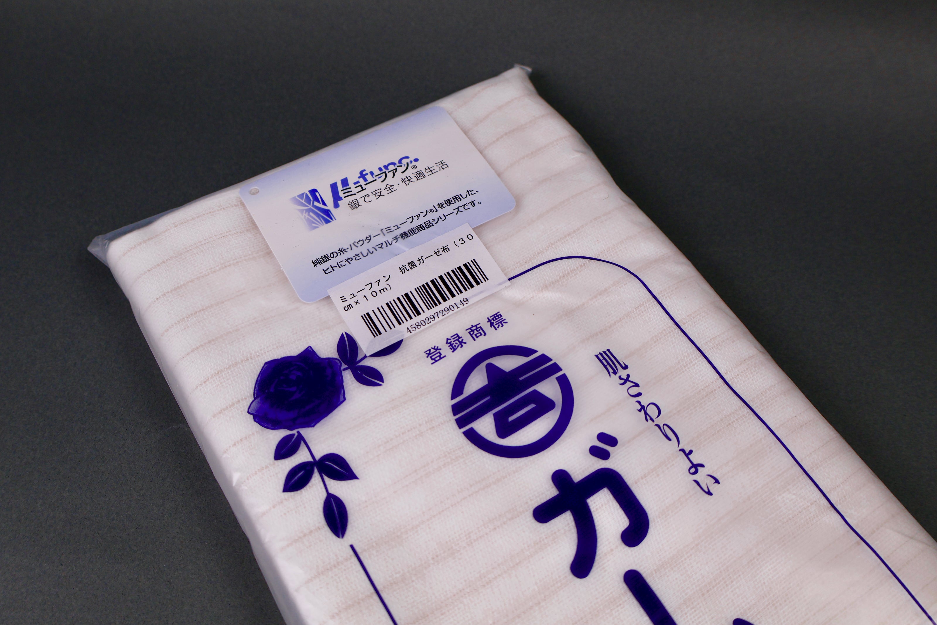 clear packaged antibacterial gauze cloth package shows blue print of hiragana and floral pattern on dark grey background