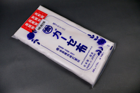 clear packaged  gauze cloth package shows blue print of hiragana and floral pattern on dark grey background