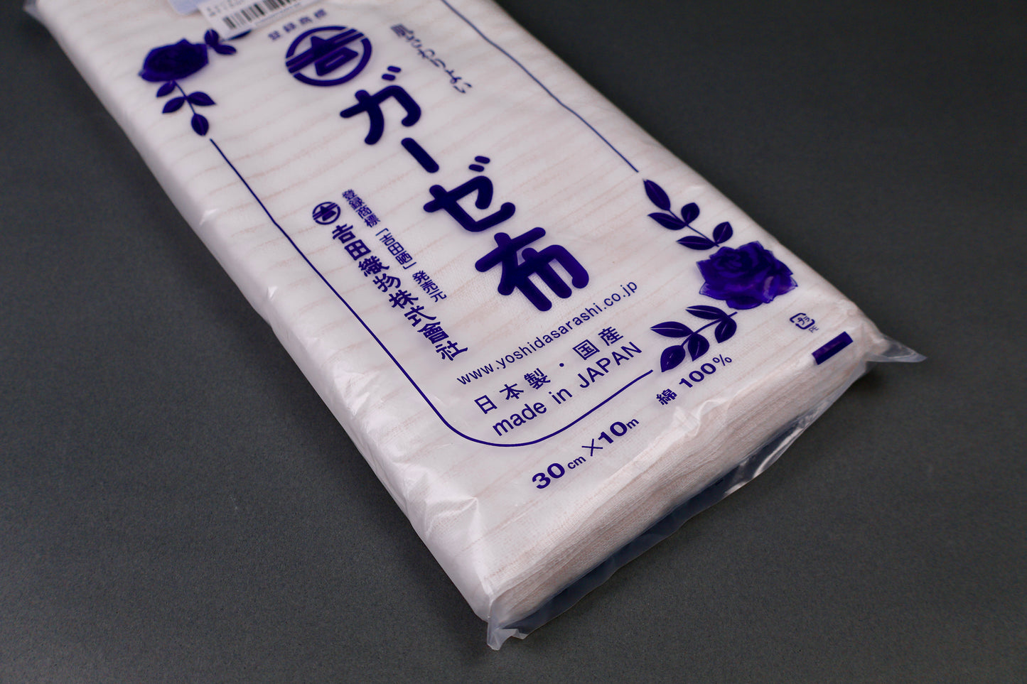 clear packaged antibacterial gauze cloth package shows blue print of hiragana and floral pattern on dark grey background