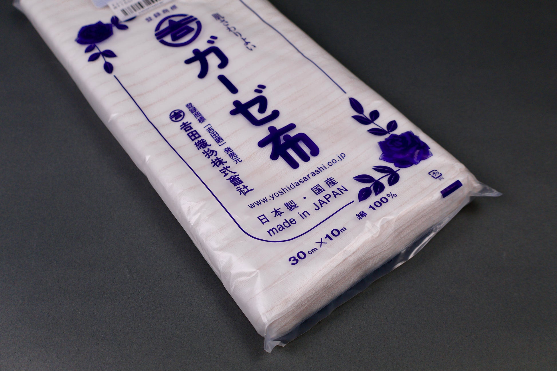 clear packaged antibacterial gauze cloth package shows blue print of hiragana and floral pattern on dark grey background