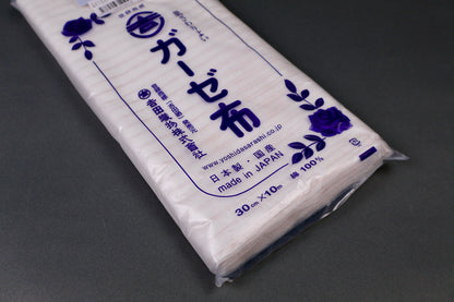 clear packaged antibacterial gauze cloth package shows blue print of hiragana and floral pattern on dark grey background