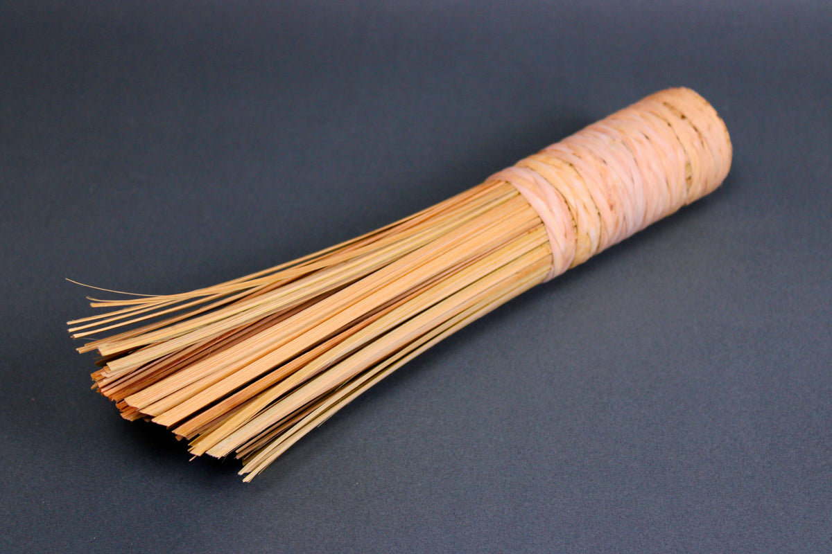 wide short woven bamboo brush thick sturdy beveled edge atop dark grey background