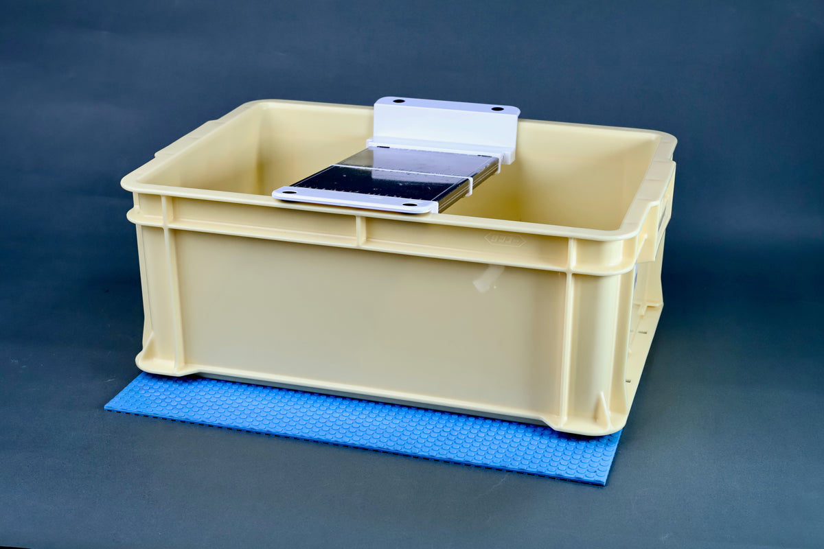 Sharpening station kit tall with whetstone loaded in white holder bridge on cream box and blue mat, grey background
