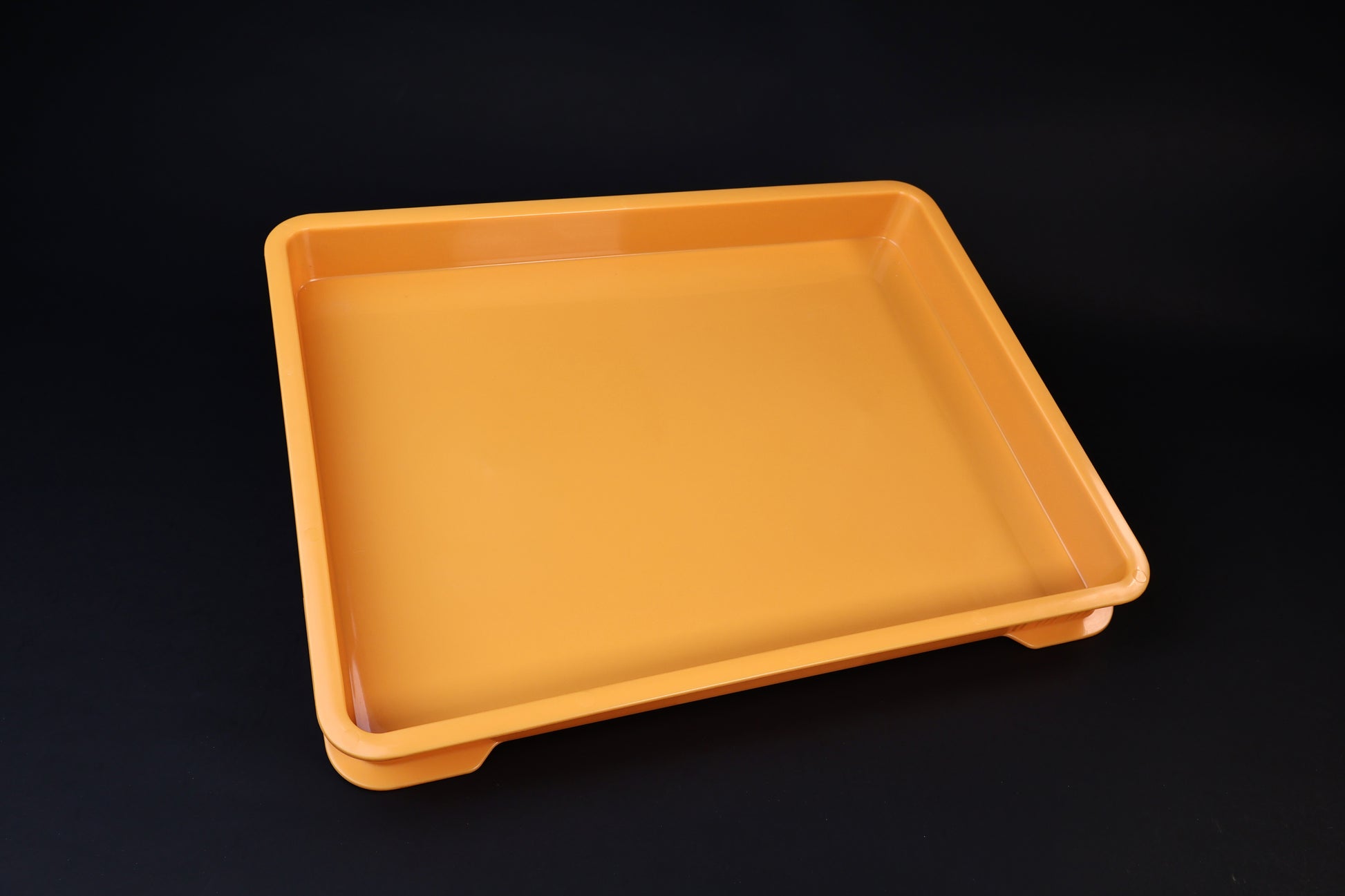 Sharpening Station Kit orange soaking tray, angled view showing interior basin and raised feet on black background