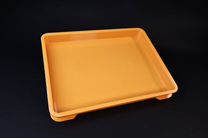 Sharpening Station Kit orange soaking tray, angled view showing interior basin and raised feet on black background